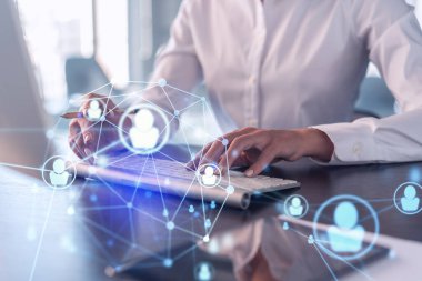 İK kadın uzmanı, işe alım sürecinde uluslararası ağ oluşturacak en iyi adayları bulmak için İnternet 'te klavyeyi yazıyor. Resmi kıyafet. Sosyal medya hologram simgeleri.