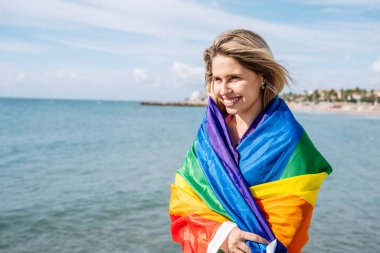 Igbti bayrağı sallayan genç bir kadın.