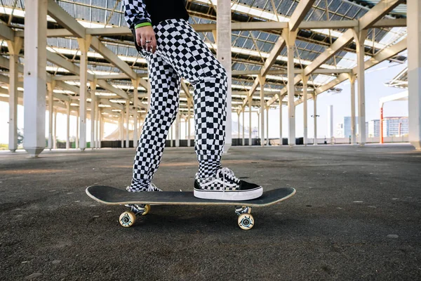 Kvinna ridning skateboard mellan konkreta pelare — Stockfoto