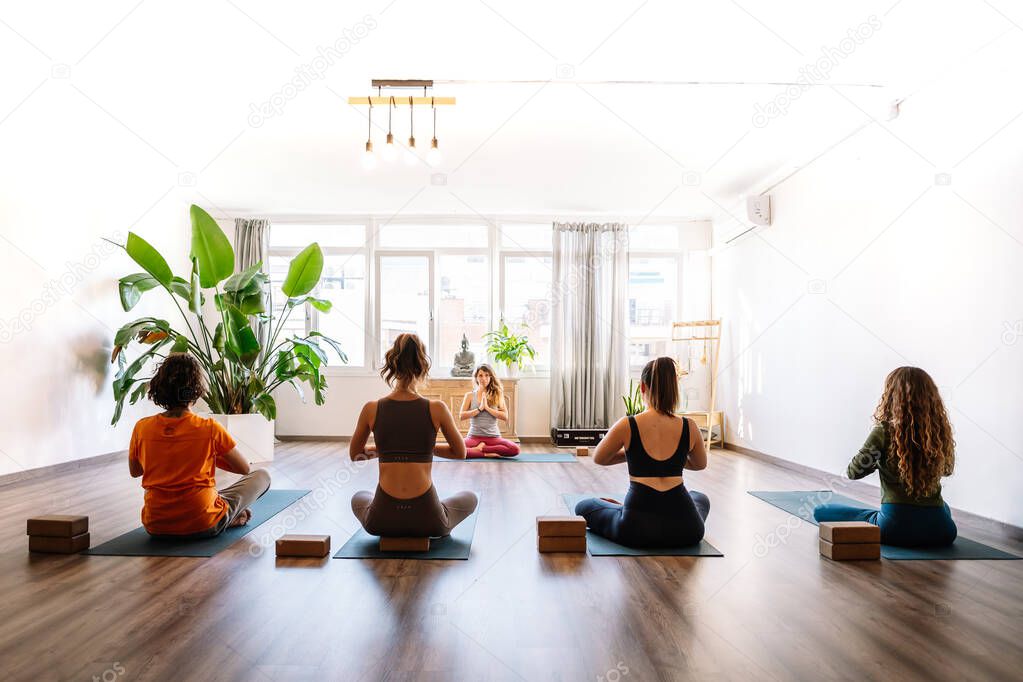 People meditating during yoga session with instructor