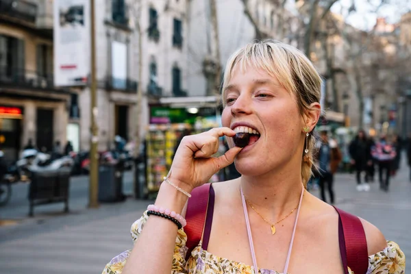 Femme heureuse manger cerise sur la rue — Photo