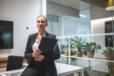 İş yerinde belgeleri olan memnun bir iş kadını.