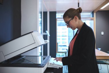 Ofiste tarayıcı kullanarak gülümseyen iş kadını