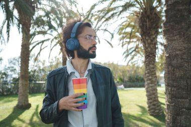 Gay with cup listening to music