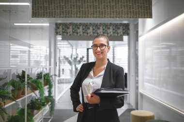 Neşeli iş kadını ofiste notlar alıyor.