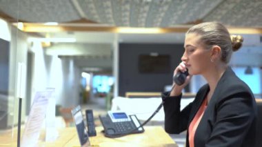 Çok uluslu resepsiyondaki bayan operatör telefona cevap veriyor. Yüksek kalite 4k görüntü