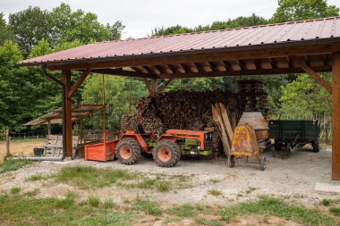 Elizondo, 28 July, 2022: tractor in a garage with firewood 
