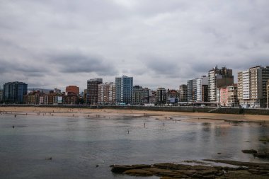 Looking along San Lorenzos beach towards the peninsula of Santa Catalina at Gijon in Asturias, Spain. High quality photo