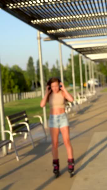 Young Woman Roller Blades Riding Park Listen Music Wireless Headphones — Stockvideo
