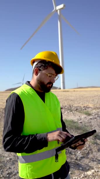 Anonymous Man Uniform Scrolling Data Tablet Blue Sky Windmill Inspection — 비디오