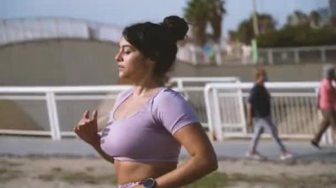 Spor tişörtlü Latin kadınlar sabah kronometreye bakmak için gezinti güvertesi boyunca koşuyorlar. Yüksek kalite 4k görüntü