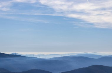Bulutlu bir gökyüzünün altındaki dağ resmi