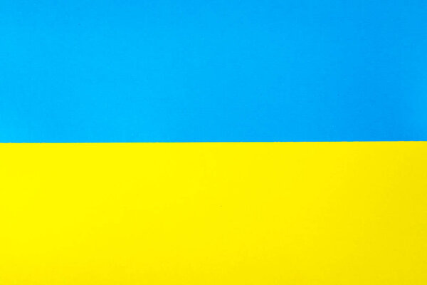 Yellow-blue (colors of the Ukrainian flag) cardboard photographed from above 