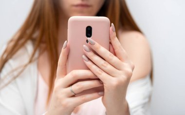 Kadın eli pembe çantalı, akıllı telefon sosyal medya kullanan, haberleri kontrol eden, mobil oyunlar oynayan ya da mesajlaşan genç bir kadın. Gadget günlük kaydı