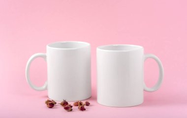 İki fincan beyaz kahve ya da pembe arka planda fotokopi alanı olan bir kupa. Tasarım, marka ve iş için boş bir şablon. Gerçek fotoğraf. Güller mini