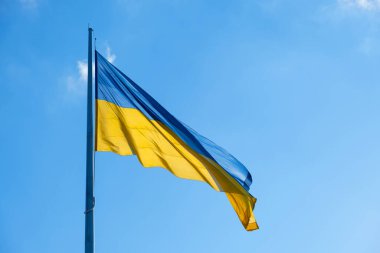 Mavi gökyüzünde dalgalanan Ukrayna bayrağı. Büyük sarı Ukrayna ulusal bayrağı. Rusya Ukrayna 'ya saldırdı