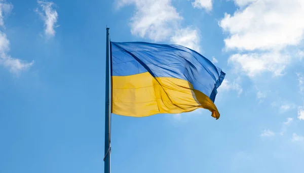 Mavi gökyüzünde dalgalanan Ukrayna bayrağı. Büyük sarı Ukrayna ulusal bayrağı. Rusya Ukrayna 'ya saldırdı