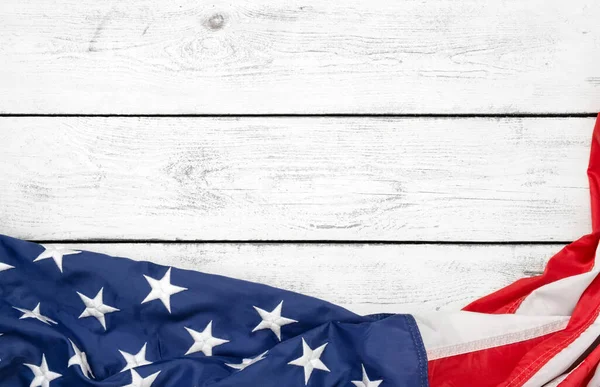 Beyaz ahşap tahtanın üzerinde düz bir Amerikan bayrağı vardı. Fotokopi alanı üst görüşü olan klasik bir arka plan. Sancak, minimalizm. Amerikalı