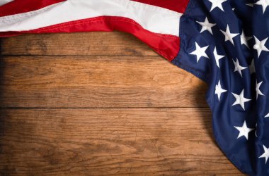 Kahverengi ahşap tahtanın üzerinde düz bir Amerikan bayrağı vardı. Fotokopi alanı üst görüşlü klasik bir arka plan. Pankart, minimalizm, çatı katı tarzı. Amerikalı