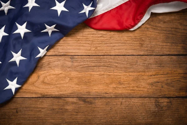 Kahverengi ahşap tahtanın üzerinde düz bir Amerikan bayrağı vardı. Fotokopi alanı üst görüşlü klasik bir arka plan. Pankart, minimalizm, çatı katı tarzı. Amerikalı