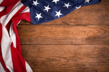 Kahverengi ahşap tahtanın üzerinde düz bir Amerikan bayrağı vardı. Fotokopi alanı üst görüşlü klasik bir arka plan. Pankart, minimalizm, çatı katı tarzı. Amerikalı