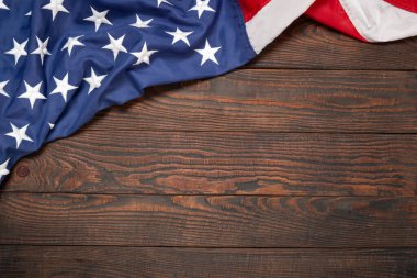 Kahverengi ahşap tahtanın üzerinde düz bir Amerikan bayrağı vardı. Fotokopi alanı üst görüşlü klasik bir arka plan. Pankart, minimalizm, çatı katı tarzı. Amerikalı