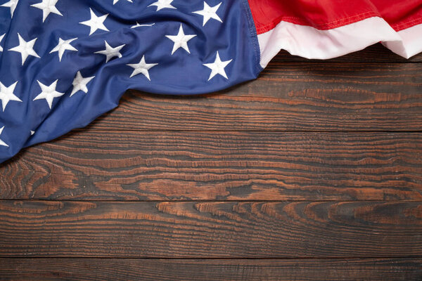 Flat lay USA flag on brown wooden board, vintage background with copy space top view. Banner, minimalism, loft style. American