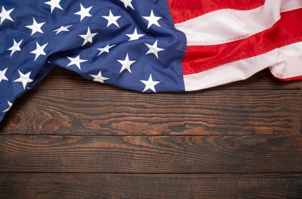 Kahverengi ahşap tahtanın üzerinde düz bir Amerikan bayrağı vardı. Fotokopi alanı üst görüşlü klasik bir arka plan. Pankart, minimalizm, çatı katı tarzı. Amerikalı