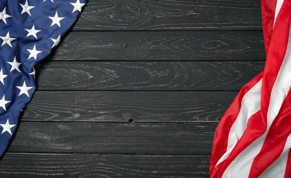 Siyah ahşap tahtanın üzerinde düz bir Amerikan bayrağı vardı. Fotokopi alanı üst görüşü olan klasik bir arka plan. Pankart, minimalizm, çatı katı tarzı. Amerikalı