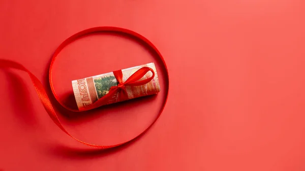 Rosyjskie pieniądze jako prezent na nowy rok - pięć tysięcy rubli ze wstążką na czerwonym tle — Zdjęcie stockowe
