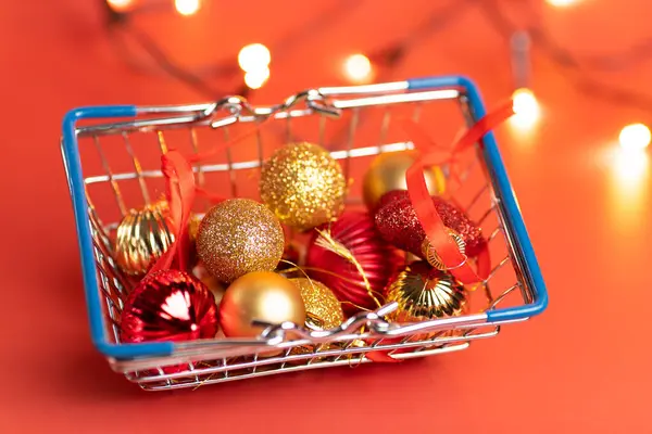 Cesto di giocattoli natalizi su sfondo rosso - palle, stelle e fiocco di neve, rosso e oro — Foto Stock