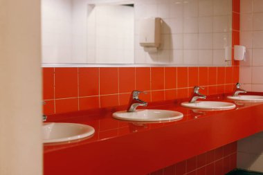 Duvarında kırmızı fayanslar olan kadınlar soyunma odası, misafirler için aynalar, alışveriş merkezinde tuvalet. Yüksek kalite fotoğraf