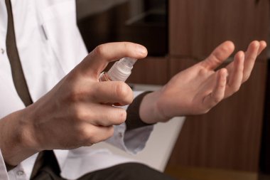 Beyaz önlüklü erkek doktor elinde antiseptik tutuyor. Yüksek kalite fotoğraf