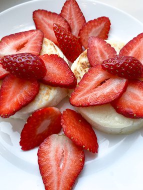 Kahvaltıda beyaz tabakta çilekli cheesecake. Yüksek kalite fotoğraf