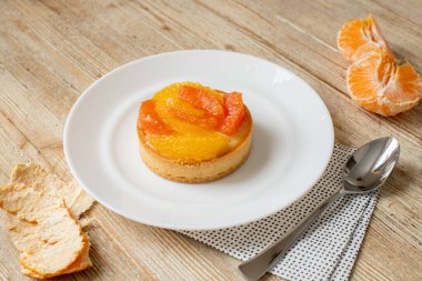 Mandalina ve greyfurtlu tart ahşap bir masanın üzerinde duruyor. Güzel tatlı. Yüksek kalite fotoğraf