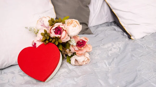 Prezent na Walentynki w postaci serca leży na łóżku - 14 lutego — Zdjęcie stockowe