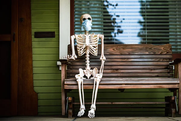 Pandemie. Skelett in einer medizinischen Maske. Impfungen im Herbst. Szenerie für Halloween im Oktober. Dekoration im Hof. — Stockfoto