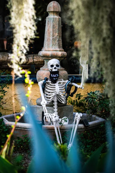 Esqueleto mascarado, pandemia de coronavírus. Cenário de Halloween em outubro. Decoração no pátio. — Fotografia de Stock