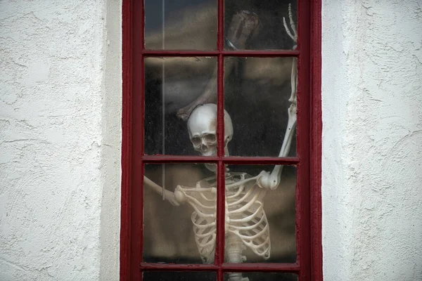 Esqueleto na casa fora da janela. Cenário de Halloween em outubro. Decoração no pátio. — Fotografia de Stock