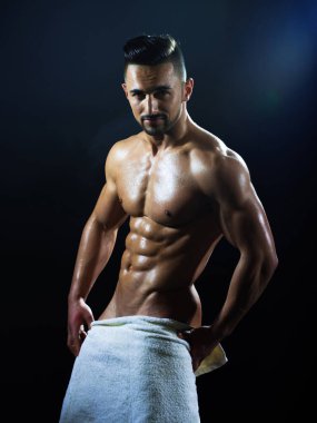 Seksi sporcu genç adam. Çıplak gövdesi ve kalçasında havlu olan kaslı bir adam..