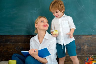 Bazı öğrenciler en iyi dinleyerek öğrenirler. Anne ve oğul okuyor..