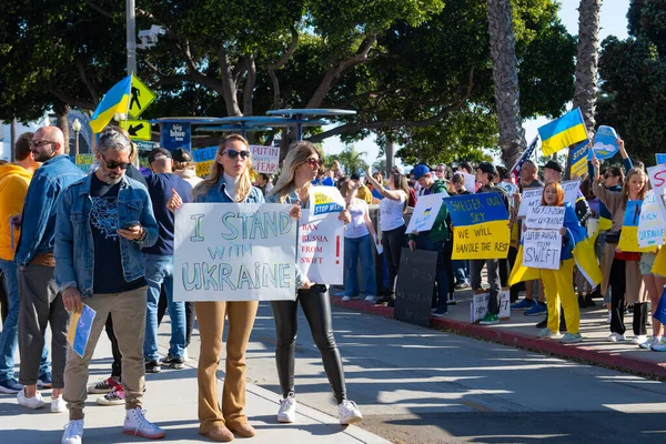 Санта-Моніка, Каліфорнія, США - 25 лютого 2022: Зупиніть Путін, зупиніть війну. Стань з Україною. Росія воює проти України, агресивно. Українці, росіяни, білоруси проти Росії. — Безкоштовне стокове фото