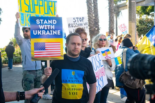 Santa Monica, California, SUA - 25 februarie 2022: Opriți-l pe Putin, opriți războiul. Stai cu Ucraina. Rusia război împotriva Ucrainei, invazie agresivă. Ucraineni, ruși, belaruși împotriva Rusiei. — Fotografie de stoc gratuită