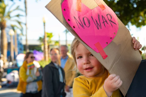 Santa Mónica, California, Estados Unidos - 25 de febrero de 2022: Un niño con un cartel contra Rusia y la guerra en Ucrania. Bebé pacifista. — Foto de stock gratis