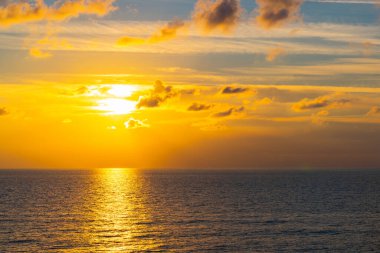 Akdeniz 'in üzerinde bulutlarla batan güneş. Turuncu renkler.