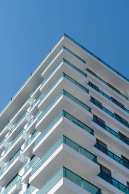 Camdan parmaklıkları olan modern bir apartmanın köşesinde..