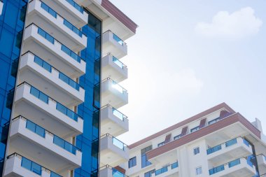 Modern lüks bir kompleksin ayrıntıları. Güneş, binaların birinin arkasından bizi gözetliyor. cam yüzey.