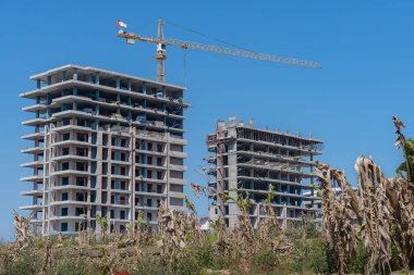 Eski bir muz çiftliğinin şantiyesinde yapım aşamasındaki çok katlı bir kompleks. Açık Gün.