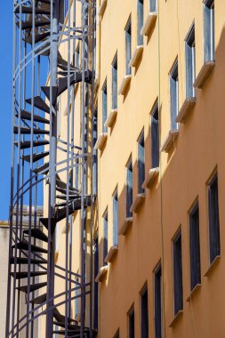 A rounded metal fire escape outside the building.