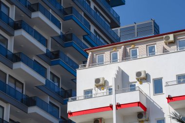 Güneşle aydınlatılan eski beyaz bir bina gölgede yeni bir gökdelenin arka planında..